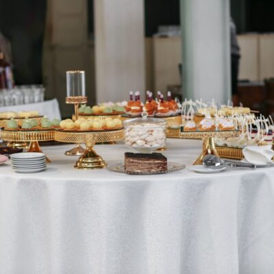 Stół z deserami na eleganckim przyjęciu, prezentujący catering weselny.
