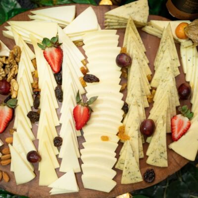 Deski serów z plasterkami serów, orzechami i owocami.