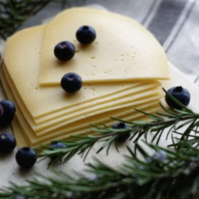 Deski serów z plasterkami sera, jagodami i gałązkami rozmarynu.