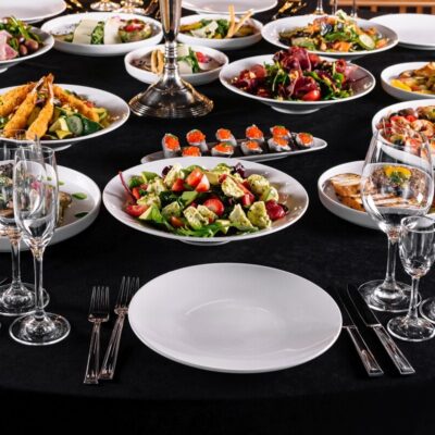 Stół pełen potraw z różnorodnym menu, świadczący o wysokiej jakości usługach cateringowych.