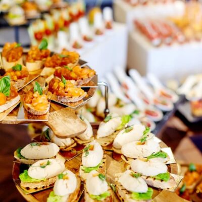 Kolorowe kanapki i przystawki na eleganckim stole, idealne jako catering na imprezy okolicznościowe.
