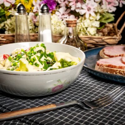 Catering na imprezy okolicznościowe: sałatka i pieczywo z wędliną na stole.