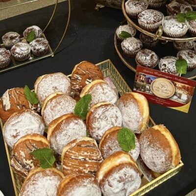 Pączki i muffiny ułożone na tacy jako catering na spotkania biznesowe.